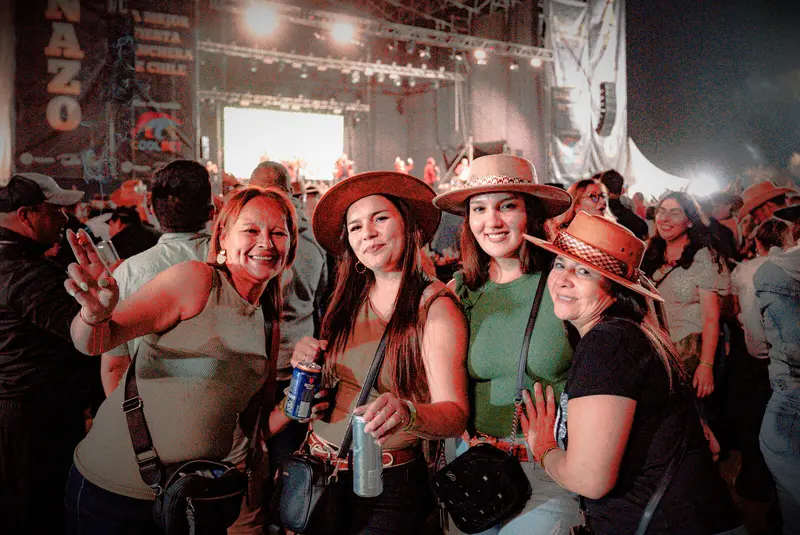 Asistentes con sombreros vaqueros posando sonrientes